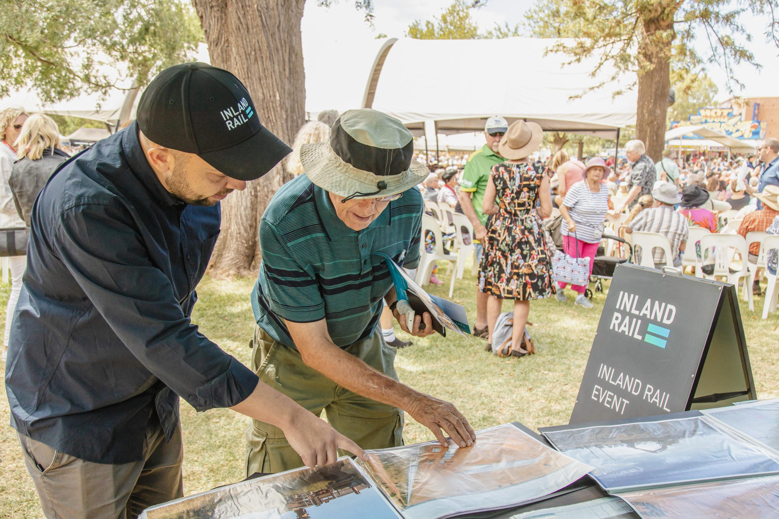 Two people examining Inland Rail information at a consultation event