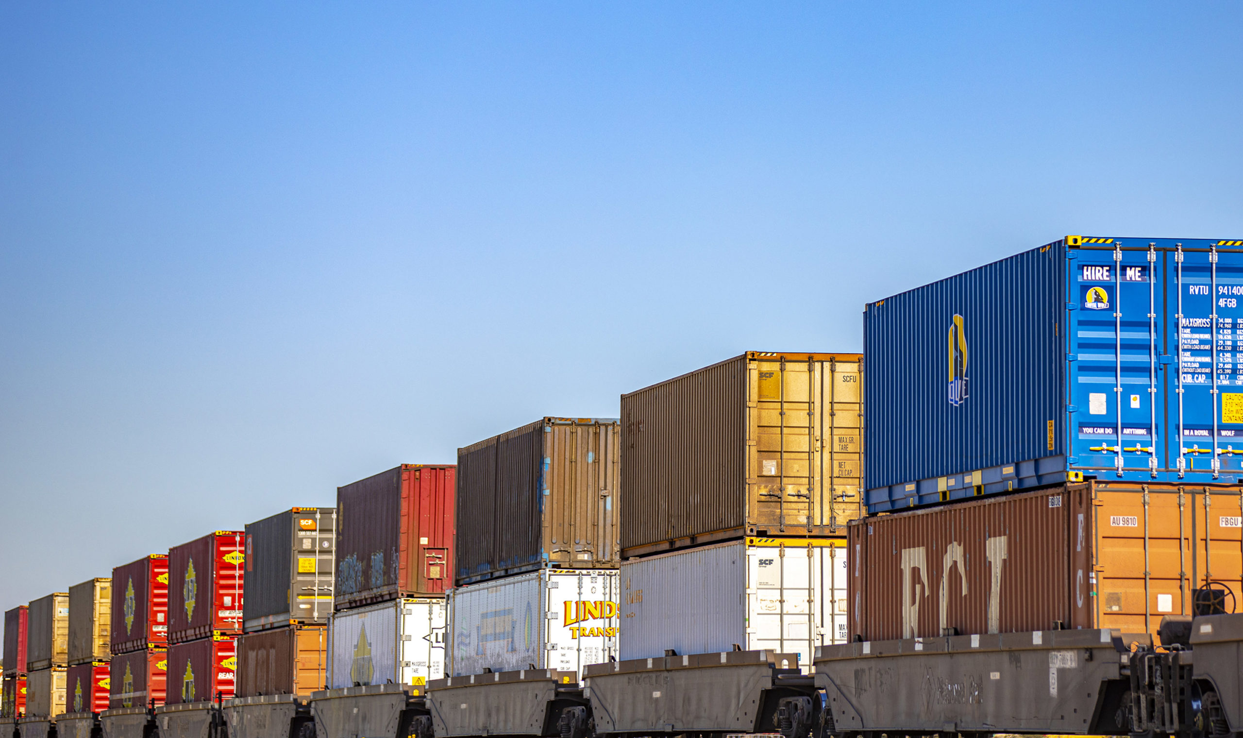 Double-stack container train travels through a rural area near Parkes, New South Wales.