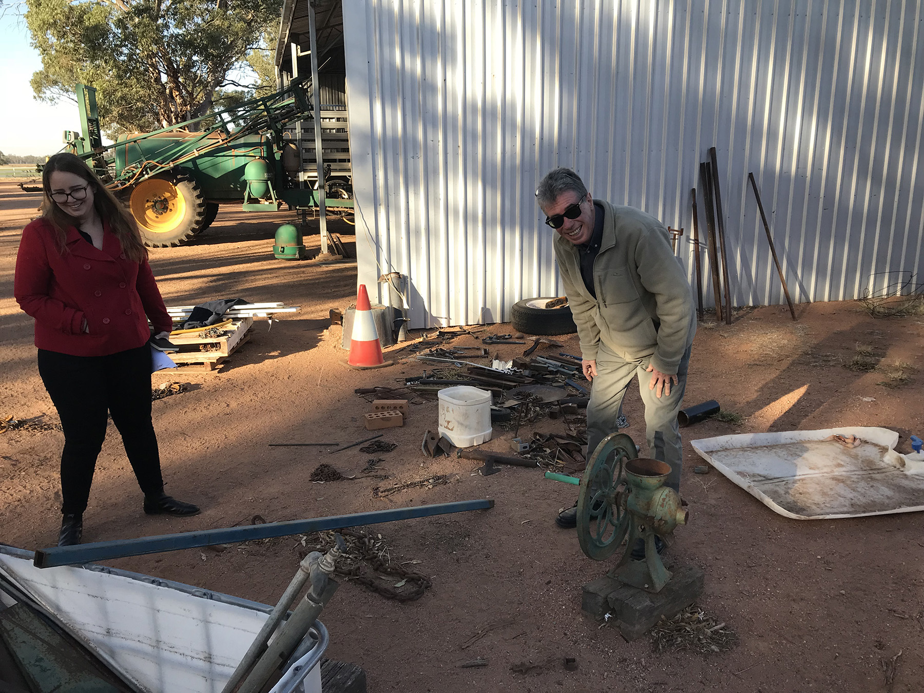 Two people standing near a shed