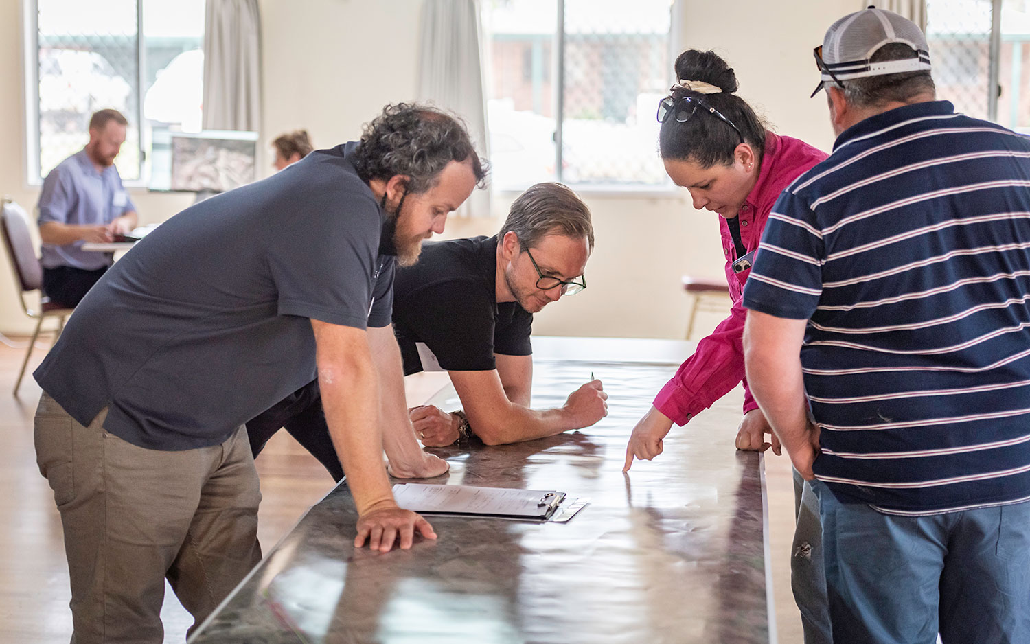 Image of community members in discussion over a map.