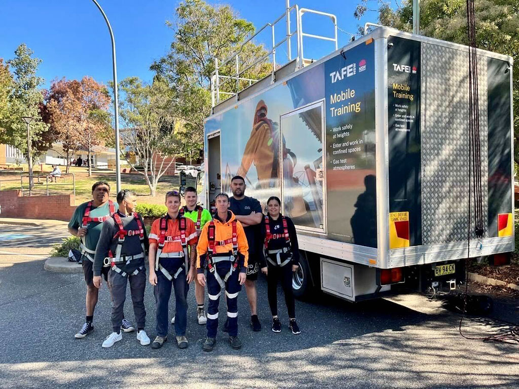 a group of people standing in front of a training truck