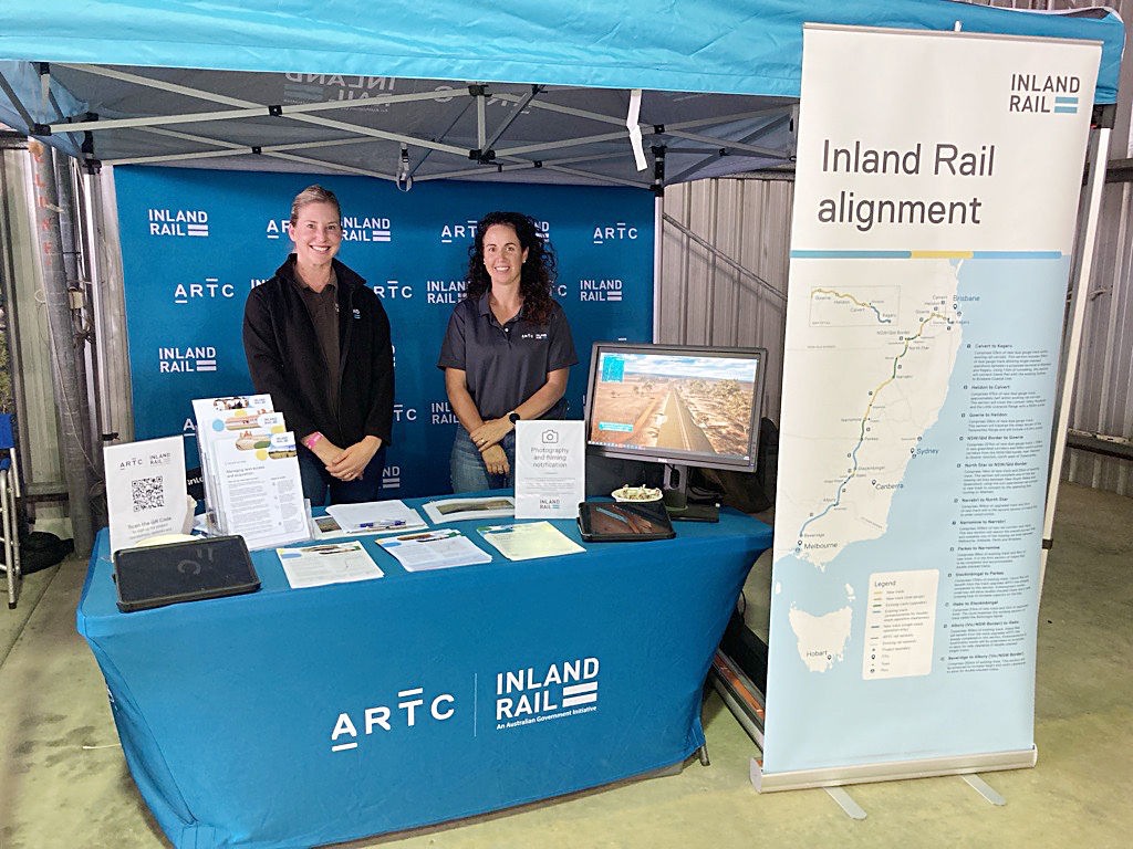 Two people standing in a show stall about Inland Rail