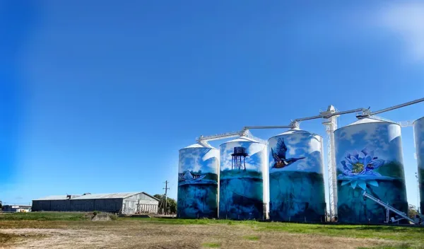 Silos painted with image people in a rural settings.