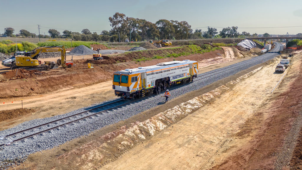 A boxy machine on a railway track that's under construction.