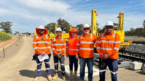 Five people standing in high visibility clothing outside