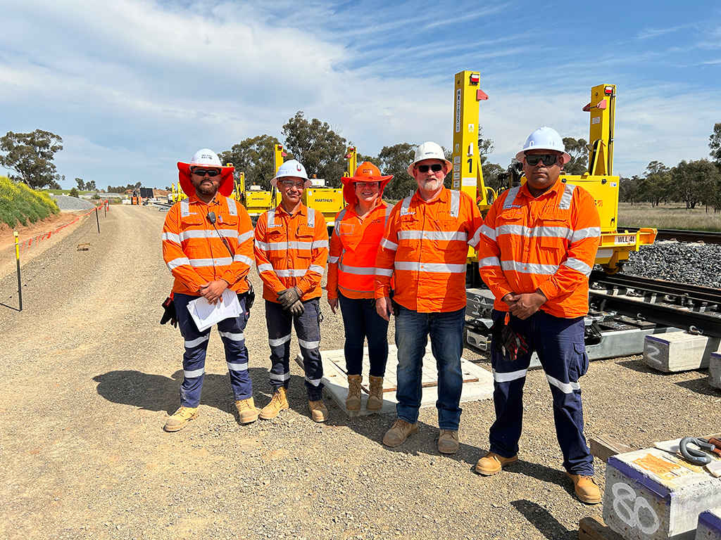 Five people standing in high visibility clothing outside