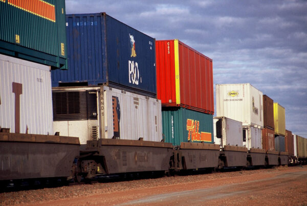 A series of train carriages with two containers stacked on top of each carriage.