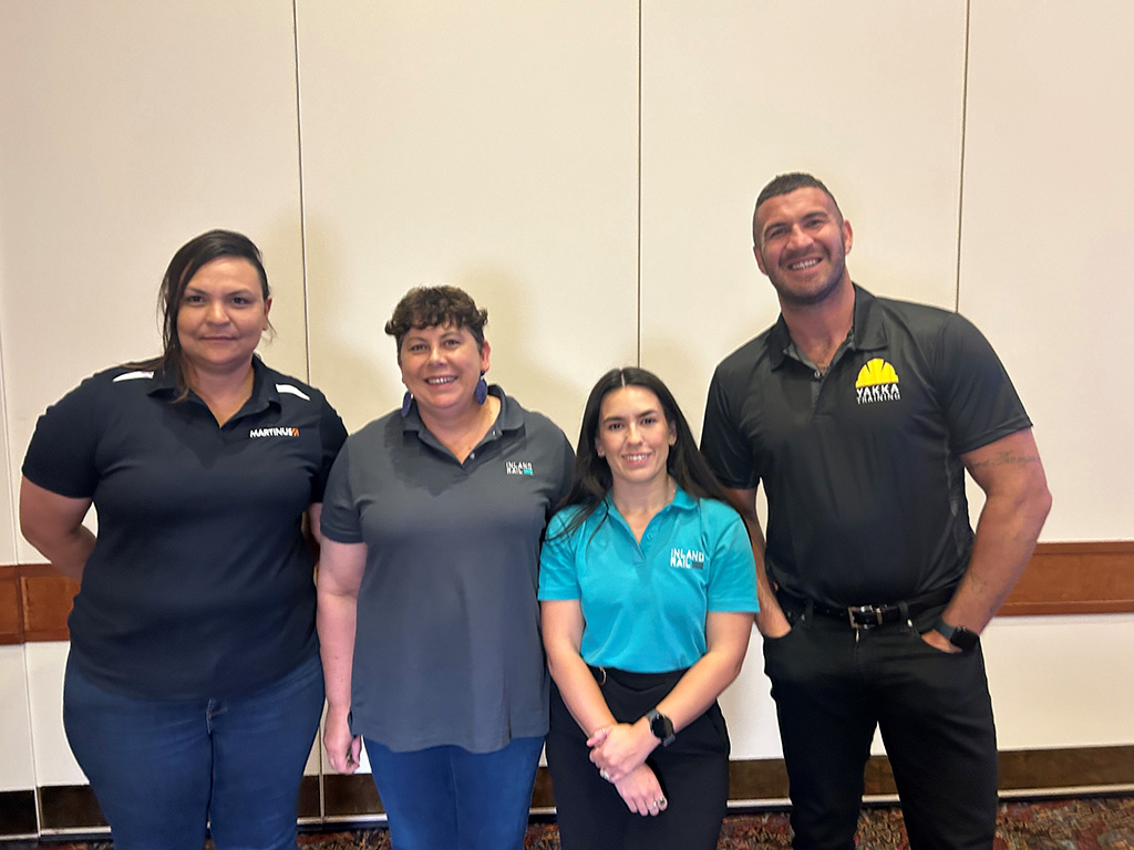 Four people standing and smiling for a photo