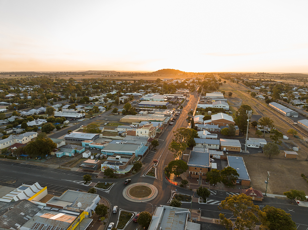 An aerial image of a town with a roundabout at sunrise