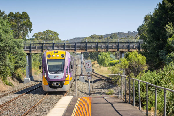 A train passes under a bridge.