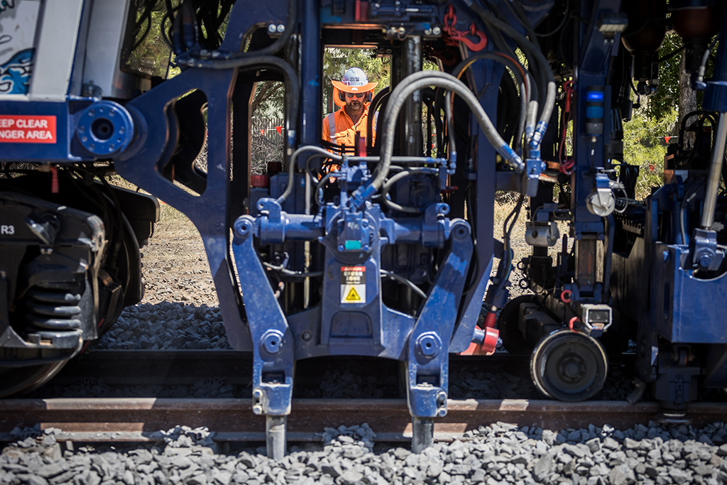 Man operating a track slew machine