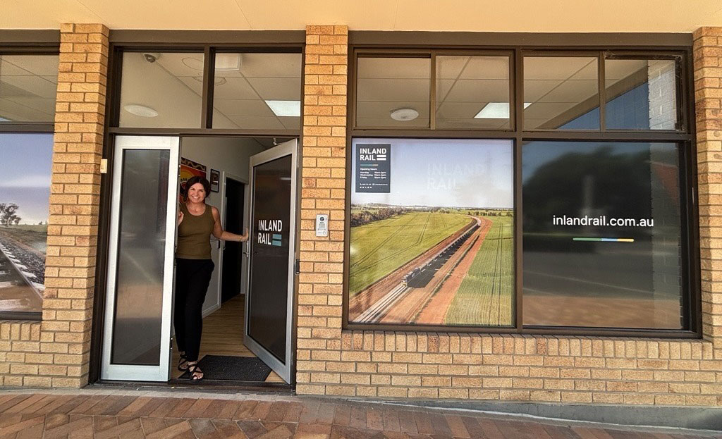 A woman stands in the open doorway of an office. 