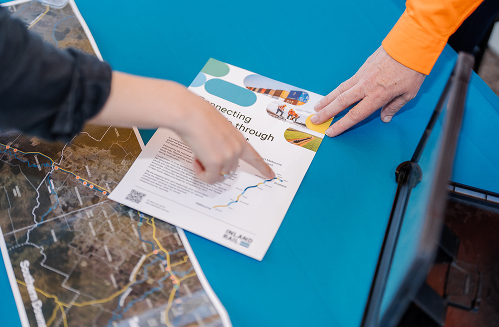 Hands of two people pointing at a brochure