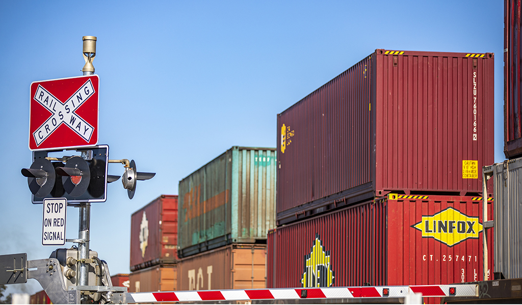 Double-stacked train passing through a level crossing