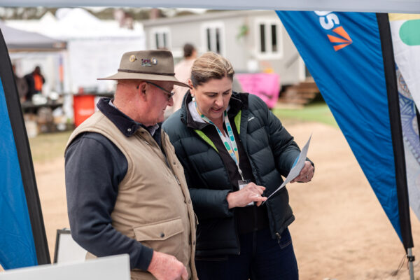 At an Inland Rail information stall, an Inland Rail employee talks to a member of the community, at a local show.
