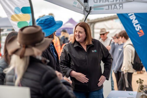 At an Inland Rail information stall, an Inland Rail employee talks to a member of the community, at a local show.