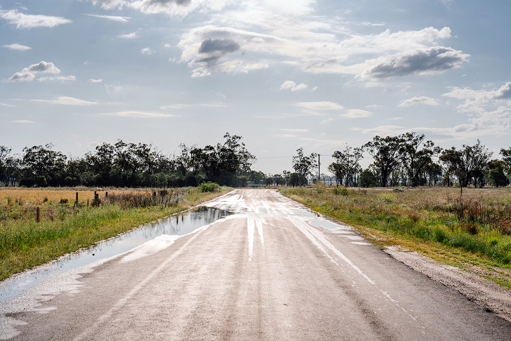 A rural road leads to an intersection in a rural area.