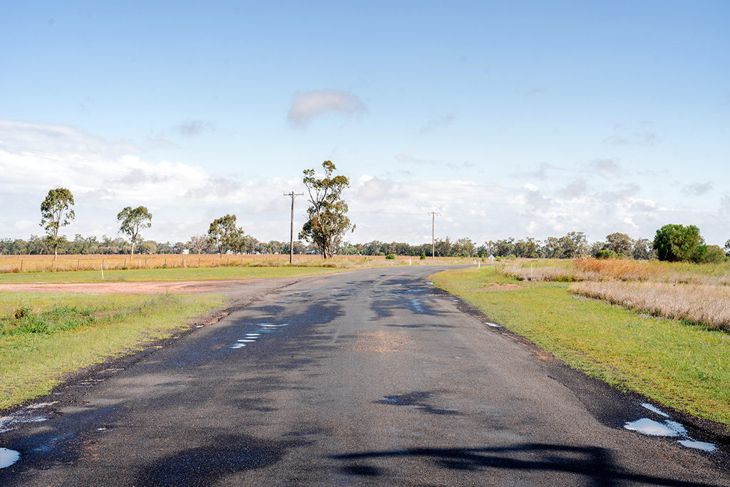 A rural road leads to an intersection in a rural area.