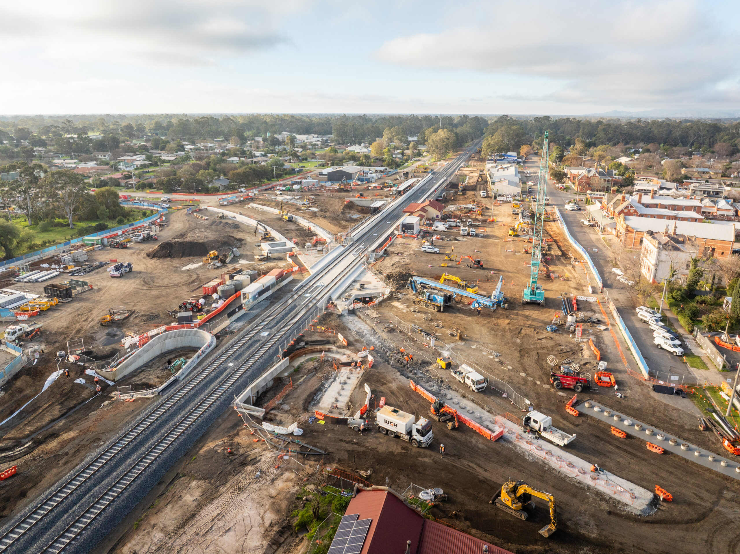 Drone aerial view of railway line under construction with blue crane.