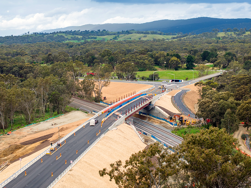 Aerial view of the new Marchbanks Road bridge crossing railway tracks with surrounding roads and bushland.
